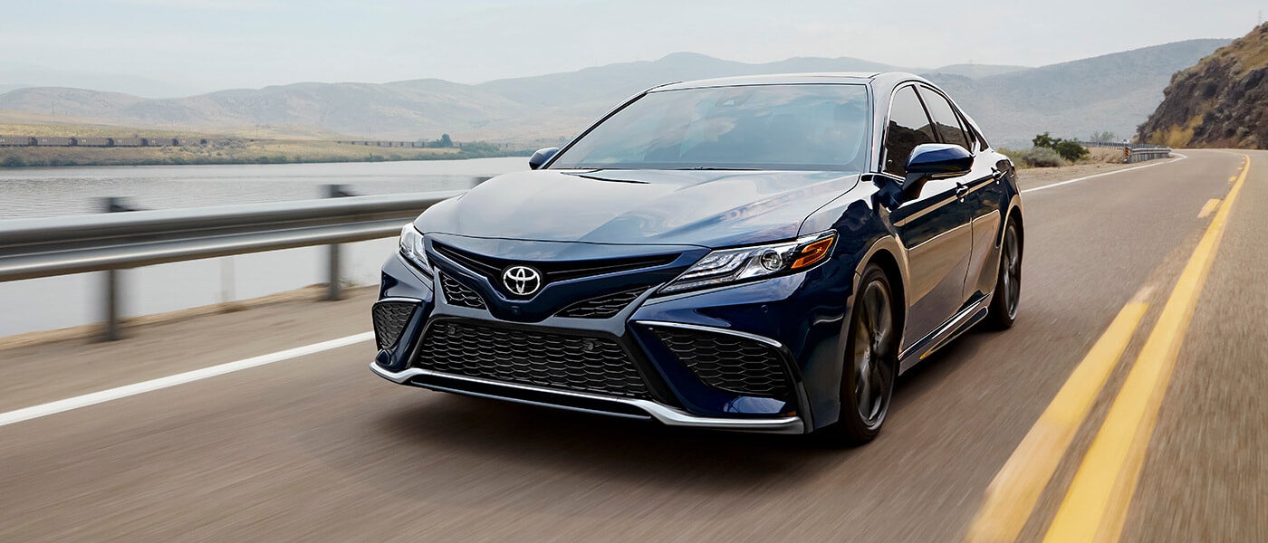 2024 Toyota Camry Hybrid exterior driving by lake
